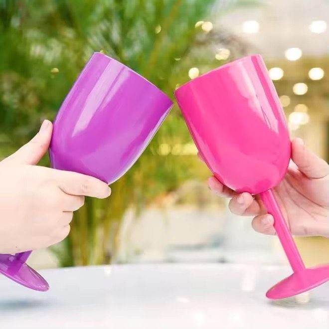 Two hands toasting with Wild Orchid and Main Character tumblers